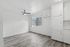 Bright, modern living space featuring sleek hardwood floors, a ceiling fan, and ample natural light from large windows.