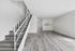 Modern open-concept interior with sleek stairs, expansive living area, and minimalist kitchen design.