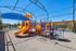 Inviting playground with vibrant slides and play structures under a shaded canopy, ideal for family enjoyment in a secure, sunny setting.