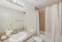 Bright and modern bathroom with elegant granite countertop, white sink, and stylish shower curtain.
