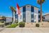 Charming Rancho Alvarado Apartments with well-maintained landscaping and striking architecture under clear blue skies.