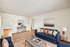 Bright and inviting living room with modern blue sofas, elegant decor, and natural light streaming in, creating a cozy ambiance. Virtually staged for inspiration.