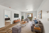 Chic living room with stylish furniture, modern decor, and natural light from a sliding glass door leading to a balcony.