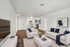 Sophisticated living room with modern decor, plush seating, and an elegant dining area leading to a sleek kitchen.