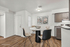 Chic dining area with a round table and elegant seating, accentuated by floral wall art and sleek kitchen cabinetry.