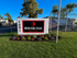 Inviting entrance sign of Wood Ridge Villas Apartments surrounded by vibrant flowers and lush greenery under a clear blue sky.