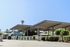 Spacious parking area with modern carports surrounded by lush greenery and clear blue sky.