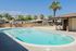 Inviting outdoor pool area with palm trees and a scenic mountain backdrop, perfect for relaxation and leisure.
