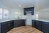 Bright, contemporary kitchen featuring sleek dark cabinets, elegant marble countertops, and modern fixtures with abundant natural light.