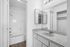Chic bathroom featuring a modern vanity with granite countertop, spacious mirror, and elegant shower-tub combo.