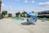 Inviting outdoor leisure area with a sparkling pool, blue sun umbrellas, and comfortable loungers, perfect for a relaxing day under the sun.