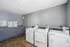 Modern laundry room featuring state-of-the-art washers and dryers, complete with user-friendly instructions and tiled flooring.