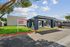 Modern Pennwood Place Apartments entrance featuring a sleek design, lush green surroundings, and ample parking space.