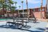 Charming apartment complex with palm trees, a refreshing pool, and outdoor seating, perfect for relaxation in a sunny setting.