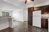 Inviting open-plan living space with sleek wood flooring, modern kitchen with dark cabinetry, and large windows for natural light.