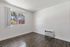 Bright and inviting room with elegant wood flooring, a large window offering a scenic view, and a convenient wall-mounted air conditioner.