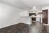 Charming open-concept living area with dark wood floors, featuring a modern kitchen with rich cabinetry and a cozy breakfast bar.