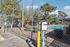 Modern apartment complex with convenient electric vehicle charging stations adjacent to a refreshing swimming pool, surrounded by lush greenery and vibrant patio umbrellas.