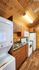 Cozy kitchen with rustic wooden cabinetry, modern white appliances, and stackable washer-dryer combo.
