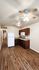 Modern kitchen with elegant dark wood cabinetry, sleek countertops, and ambient lighting featuring a ceiling fan for comfort.