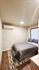 Cozy bedroom with modern decor, featuring a comfortable bed, sleek air conditioning, and warm wood flooring.