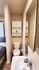 Cozy bathroom with a sleek sink, modern fixtures, and compact storage, adjacent to a comfortable bedroom.