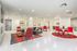 resident lounge with white flooring and red accents and red chairs