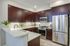 fully stocked kitchen with stainless steel appliances and espresso cabinets and a breakfast bar
