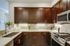 fully stocked kitchen with stainless steel appliances and espresso cabinets
