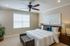 staged bedroom with plush carpeting and a ceiling fan