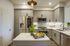 fully stocked kitchen with white cabinets and kitchen island