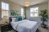 bedroom with large windows and unique light fixture