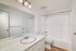 bathroom with large mirror sink storage toilet and shower tub combo