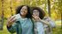 two women taking a selfie in a park with trees