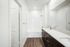 Bathroom at Paseo Village with white counters and two sinks and dark cabinets