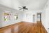 living space with wooden floor, ceiling fan, and window