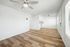 living space with wooden floor, ceiling fan, and windows