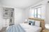 virtually staged bedroom with built-in storage in a large closet
