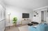 Virtually staged living room with window coverings, wood-style flooring, and built-in storage