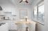 virtually staged dining area with ceiling fan and kitchen