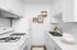 virtually staged kitchen with quartz countertops, farmhouse style sink, and updated cabinets