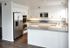 Villas at La Costa updated kitchen with stainless steel appliances and wood-style vinyl plank flooring and grey stone countertops