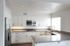 Villas at La Costa updated kitchen with stainless steel appliances and wood-style vinyl plank flooring and grey stone countertops