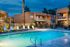 lit pool with lounge chairs at Metro on Main at night