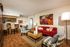 living room with vinyl wood like flooring and red sofa and 2 arm chairs at Metro on Main
