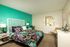bedroom with green accent wall and furnished with bed and nightstands at metro on main