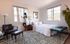 woman looking out window in bedroom with bed and brown arm chair at oasis 20