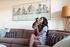 woman holding dog while sitting on sofa at oasis 20