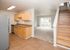 galley kitchen with birch cabinets and vinyl wood like flooring and stainless steel appliances