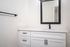 Updated bathroom with white shaker cabinets and white hard-surface countertop